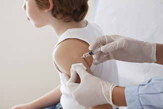 Child receiving immunization from nurse